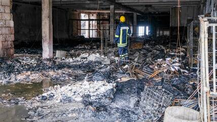 Alles zerstört: Brandermittler suchen die völlig verwüstete Halle nach Hinweisen auf die Ursache ab.